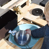 Our mud kitchen includes a working tap, water dispenser, a sliding draining board to reveal a large splash tub, an oven, hobs, shelves and cupboard 