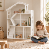Four-year-old girl reading on a cream rug beside the wooden dolls’ house bookcase.