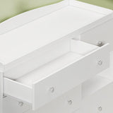 Close-up of round white drawer knobs on a nursery storage unit