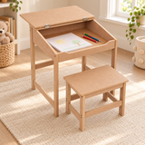 Four-year-old child drawing at a natural MDF desk while seated on the matching stool.