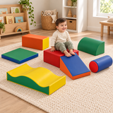 Toddler sitting on the red foam platform with feet resting on the blue ramp
