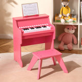 Pink children's piano with stool in a room setting with toys and books.