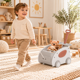 Three year old boy pulling toy walker cart using front cord