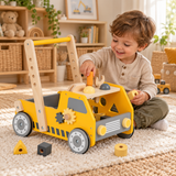 Young boy sitting beside wooden walker and playing with toy tools