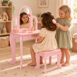 Two girls playing hairdressers at a pink children’s dressing table with triple mirror, storage drawer and matching stool