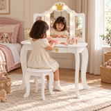 Three-year-old girl choosing a hair bow at an illuminated children’s dressing table