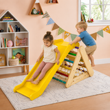 Child playing on wooden pikler triangle with yellow slide