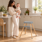 Grey 4-in-1 wooden highchair with tray and cushioned seat during baby feeding.
