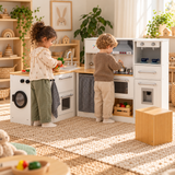 little girl and boy playing together at their deluxe wooden toy kitchen