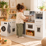 little girl pretend cooking on her deluxe multi functional white toy kitchen