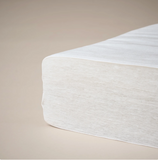 White cot mattress on a beige background