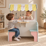 Children playing café with a striped canopy, serving counter and attached seats
