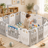Toddler exploring the steering wheel and activity panel inside a folding baby playpen