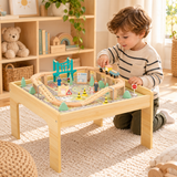 Three-year-old boy playing with the 50-piece wooden train table.