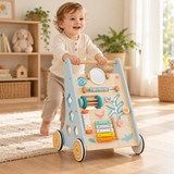 Toddler pushing a blue wooden activity walker in a neutral Little Helper playroom.