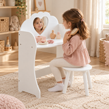 Three-year-old girl brushing her hair at a white heart mirror dressing table