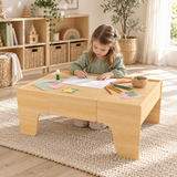 Child drawing at the wooden craft table in the Little Helper brand playroom.
