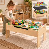 Three-year-old girl playing with a wooden train table in a neutral Little Helper playroom.