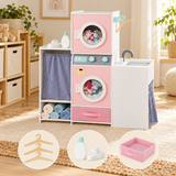 Pink wooden toy laundry playset in a neutral playroom with accessory cameos showing hangers, toy iron and detergent bottle