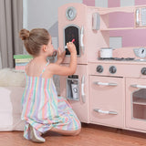 Esta cocina de juguete rosa tiene abundantes funciones, como dispensador de agua, teléfono inalámbrico, reloj, microondas y pizarra. 