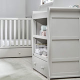 La commode avec meuble à langer Willow comprend trois étagères où vous pourrez ranger les essentiels et accessoires de votre chambre de bébé.