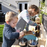 Esta cocina de barro resistente es lo suficientemente grande como para que dos niños trabajen mientras crean obras maestras de barro.