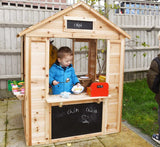 Wunderschön gefertigtes Outdoor-Holzspielhaus aus Naturtannenholz für Kinder | Café | Einkaufen | 18m+Dieses niedliche Holzspielhaus ist eine Reihe fantasievoller Orte, ein Geschäft, ein Café, eine Ticketstation, ein Postamt oder ein Restaurant.