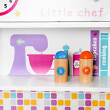 The toy kitchen includes a shelf for storing cook books and more